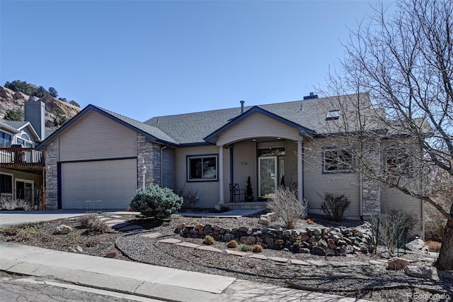 5130 Sevenoaks Dr, Colorado Springs, CO 80919 - view of front facade with a shingled roof, an attached garage, stone siding, and concrete driveway