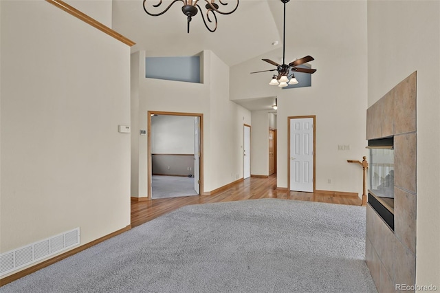5130 Sevenoaks Dr, Colorado Springs, CO 80919 - unfurnished living room featuring high vaulted ceiling, visible vents, wood finished floors, and a tile fireplace