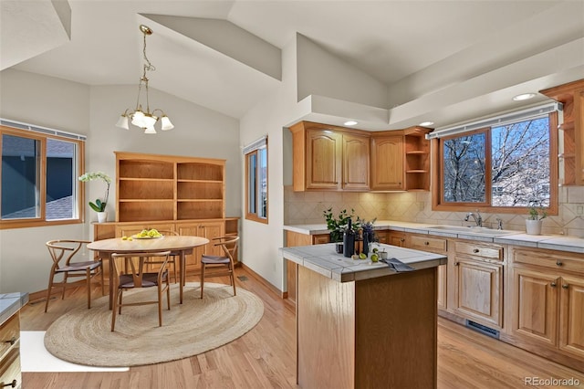 5130 Sevenoaks Dr, Colorado Springs, CO 80919 - kitchen featuring light wood finished floors, lofted ceiling, tile countertops, a sink, and open shelves