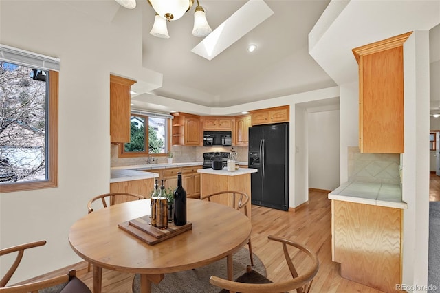 5130 Sevenoaks Dr, Colorado Springs, CO 80919 - interior space featuring light countertops, black appliances, light wood-type flooring, and tasteful backsplash