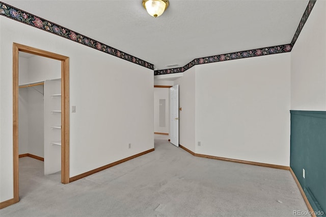 5130 Sevenoaks Dr, Colorado Springs, CO 80919 - unfurnished bedroom with a walk in closet, carpet, baseboards, and a textured ceiling