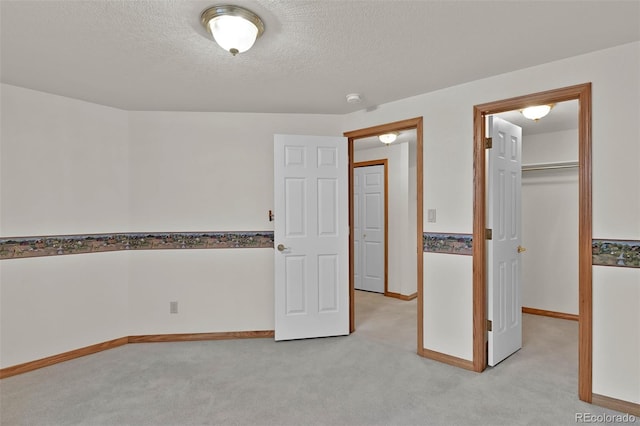 5130 Sevenoaks Dr, Colorado Springs, CO 80919 - unfurnished bedroom featuring baseboards, a textured ceiling, a walk in closet, and light colored carpet