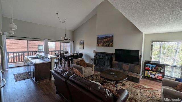 2710 Ryan Gulch Rd Unit 2731, Silverthorne, CO 80498 - living room featuring high vaulted ceiling, dark wood finished floors, a chandelier, and a fireplace