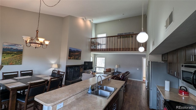 2710 Ryan Gulch Rd Unit 2731, Silverthorne, CO 80498 - kitchen with a sink, a high ceiling, stainless steel appliances, a fireplace, and a chandelier
