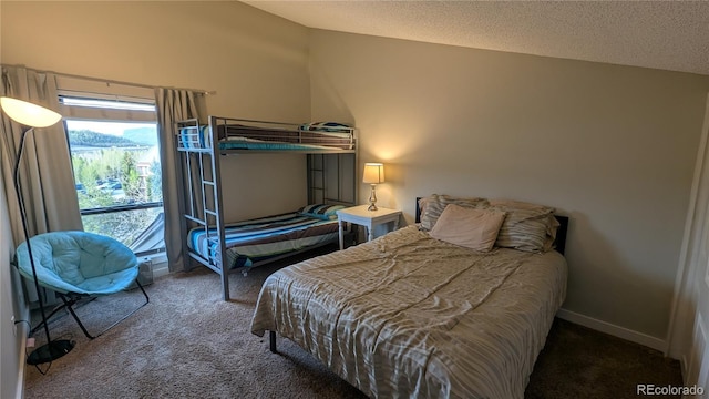 2710 Ryan Gulch Rd Unit 2731, Silverthorne, CO 80498 - carpeted bedroom featuring multiple windows, vaulted ceiling, a textured ceiling, and baseboards