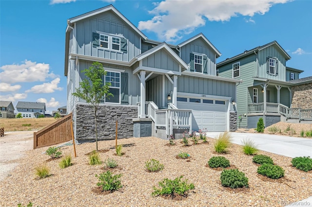 craftsman-style home featuring stone siding, board and batten siding, driveway, and a garage