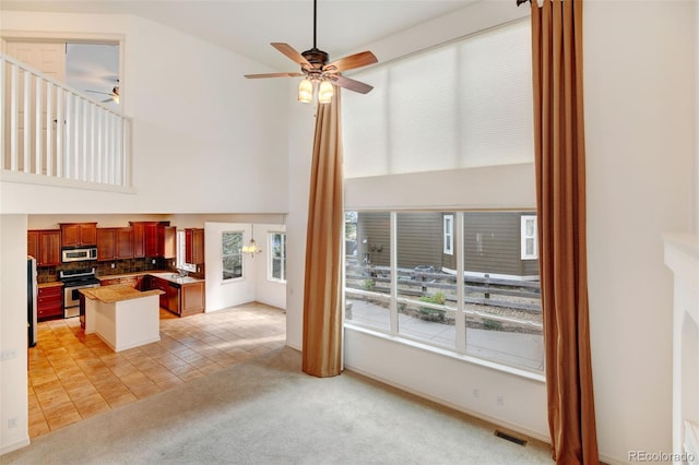 living room featuring light colored carpet, sink, ceiling fan, and lofted ceiling