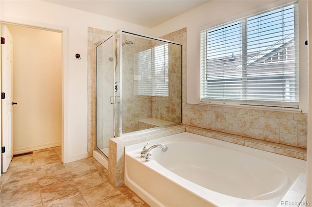 bathroom featuring a healthy amount of sunlight and plus walk in shower