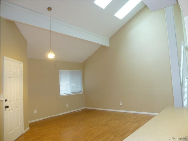 empty room with high vaulted ceiling, a skylight, wood-type flooring, and beam ceiling