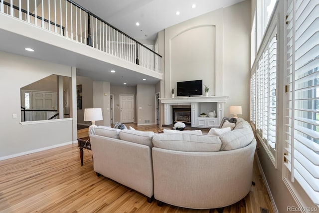 living room with a high ceiling and light hardwood / wood-style floors