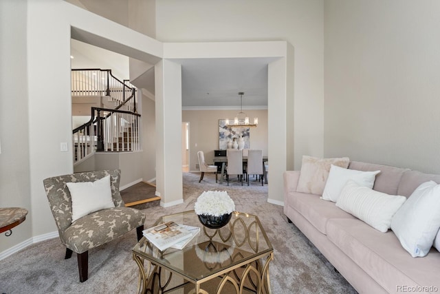 carpeted living room featuring crown molding and an inviting chandelier