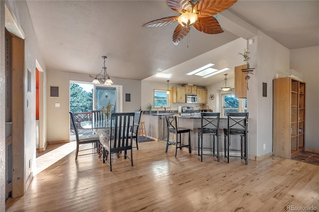 dining space featuring a skylight, light wood-style floors, and ceiling fan