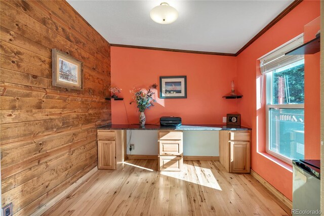office with wooden walls, crown molding, baseboards, and light wood finished floors
