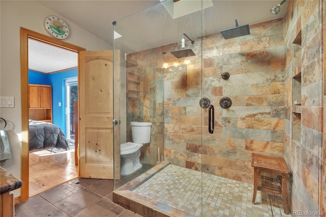ensuite bathroom featuring tiled shower, ensuite bathroom, and toilet
