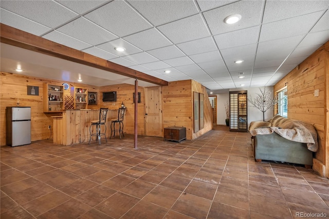 living room featuring recessed lighting, wooden walls, and dark tile patterned floors