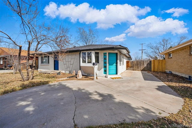 view of front facade with fence, brick siding, and driveway