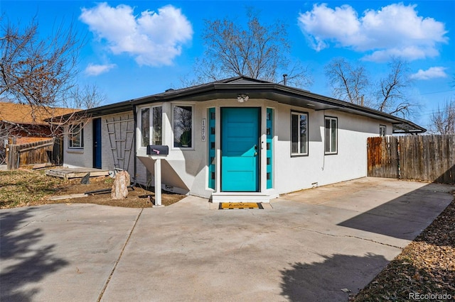 single story home featuring stucco siding and fence