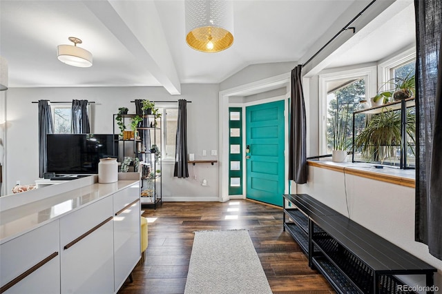 foyer featuring dark wood finished floors, baseboards, and lofted ceiling