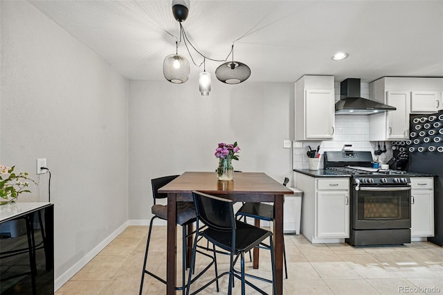 kitchen featuring dark countertops, light tile patterned flooring, wall chimney exhaust hood, and gas range oven