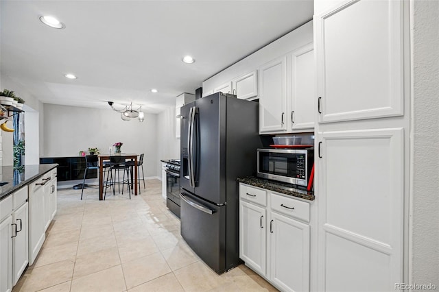 kitchen with fridge with ice dispenser, stainless steel microwave, white cabinets, light tile patterned floors, and stove