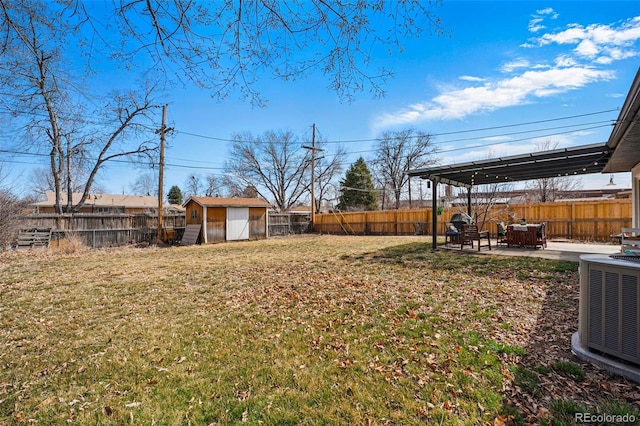 view of yard featuring an outbuilding, a fenced backyard, cooling unit, and a patio