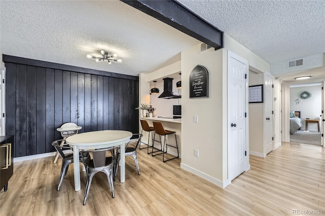 12131 Melody Dr Unit 201, Denver, CO 80234 - dining space featuring a textured ceiling, wood finished floors, and wooden walls