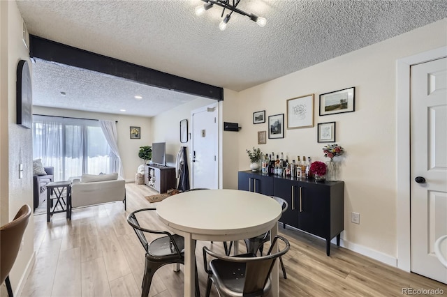 12131 Melody Dr Unit 201, Denver, CO 80234 - dining area with light wood finished floors, a textured ceiling, and a chandelier