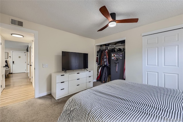 12131 Melody Dr Unit 201, Denver, CO 80234 - bedroom featuring a closet, light carpet, ceiling fan, and a textured ceiling