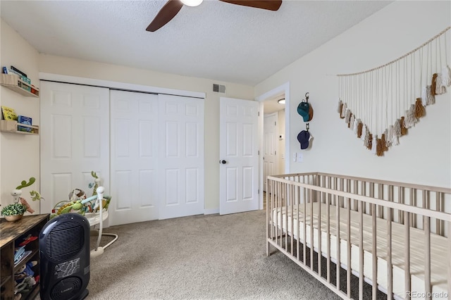 12131 Melody Dr Unit 201, Denver, CO 80234 - bedroom featuring a closet, carpet flooring, a crib, a textured ceiling, and ceiling fan