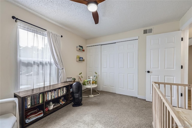 12131 Melody Dr Unit 201, Denver, CO 80234 - bedroom with carpet flooring, a textured ceiling, a closet, and a ceiling fan