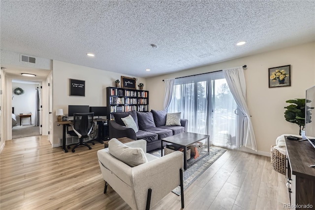 12131 Melody Dr Unit 201, Denver, CO 80234 - living area featuring a textured ceiling, light wood finished floors, recessed lighting, and a desk