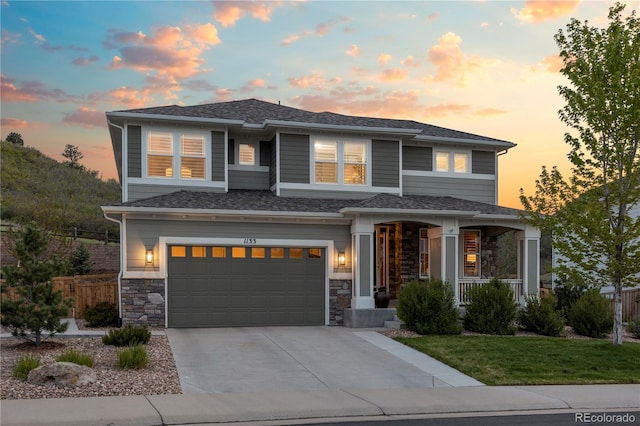 1133 Lucky Ct, Castle Rock, CO 80109 - prairie-style house featuring a garage, a porch, driveway, and stone siding