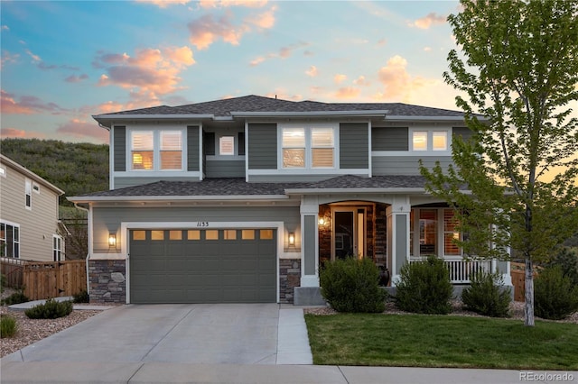 1133 Lucky Ct, Castle Rock, CO 80109 - view of front facade featuring an attached garage, concrete driveway, stone siding, and a porch