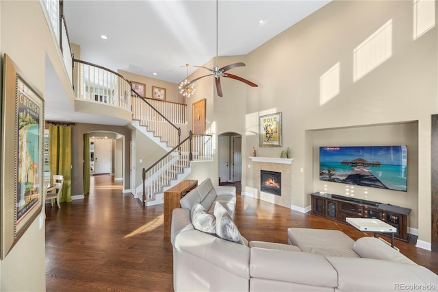 1133 Lucky Ct, Castle Rock, CO 80109 - living room with arched walkways, a high ceiling, stairway, a glass covered fireplace, and wood finished floors