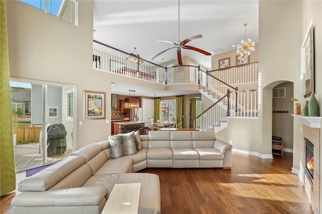 1133 Lucky Ct, Castle Rock, CO 80109 - living area featuring a high ceiling, wood finished floors, a glass covered fireplace, a ceiling fan, and stairway