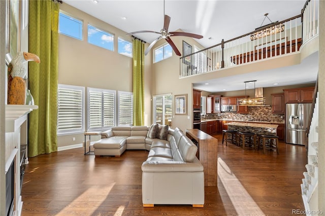 1133 Lucky Ct, Castle Rock, CO 80109 - living room featuring ceiling fan, dark wood finished floors, a high ceiling, a stone fireplace, and recessed lighting