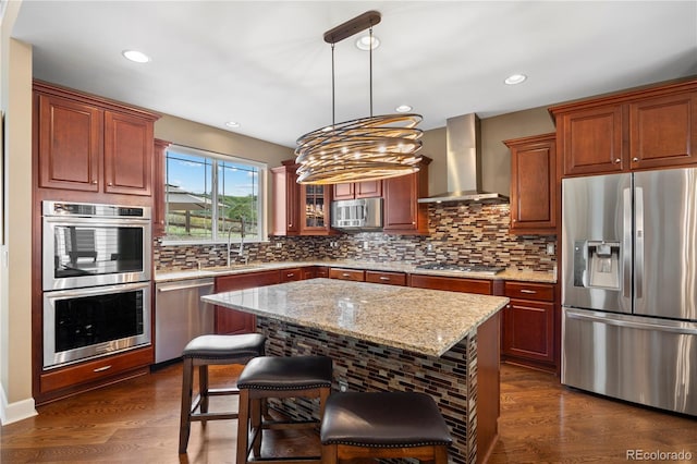 1133 Lucky Ct, Castle Rock, CO 80109 - kitchen featuring appliances with stainless steel finishes, wall chimney range hood, a sink, backsplash, and a kitchen bar