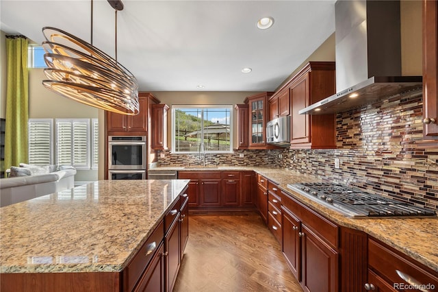 1133 Lucky Ct, Castle Rock, CO 80109 - kitchen featuring wall chimney exhaust hood, appliances with stainless steel finishes, a sink, light stone countertops, and glass insert cabinets