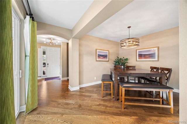 1133 Lucky Ct, Castle Rock, CO 80109 - dining room featuring a chandelier, arched walkways, wood finished floors, and baseboards