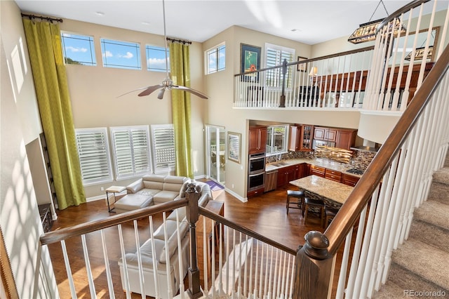 1133 Lucky Ct, Castle Rock, CO 80109 - staircase with wood finished floors, baseboards, a high ceiling, and a ceiling fan