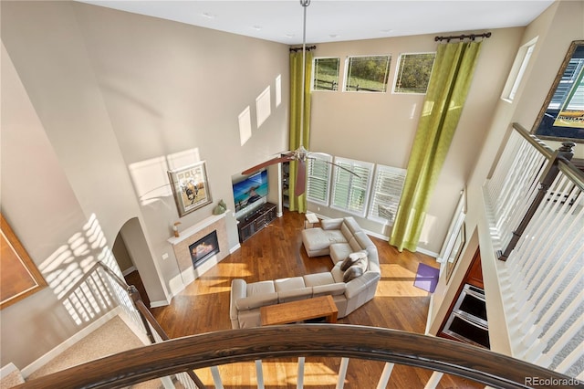 1133 Lucky Ct, Castle Rock, CO 80109 - living room featuring a towering ceiling, wood finished floors, a tile fireplace, and baseboards