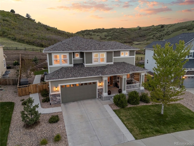 1133 Lucky Ct, Castle Rock, CO 80109 - view of front of property with covered porch, driveway, an attached garage, stone siding, and a shingled roof