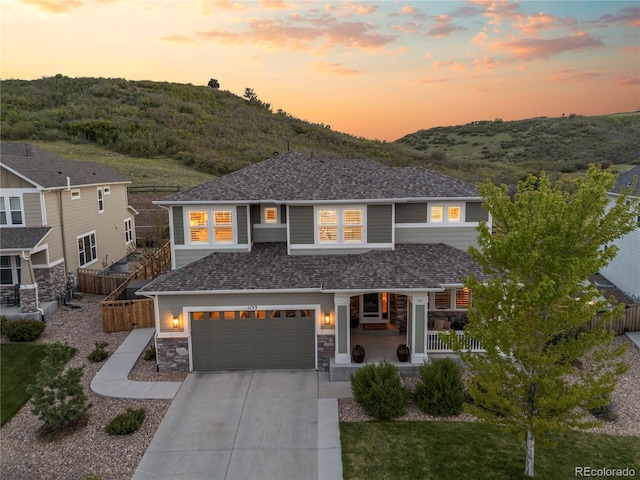 1133 Lucky Ct, Castle Rock, CO 80109 - view of front of property featuring covered porch, driveway, an attached garage, stone siding, and a shingled roof