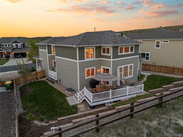 1133 Lucky Ct, Castle Rock, CO 80109 - back of house at dusk featuring a wooden deck and a shingled roof