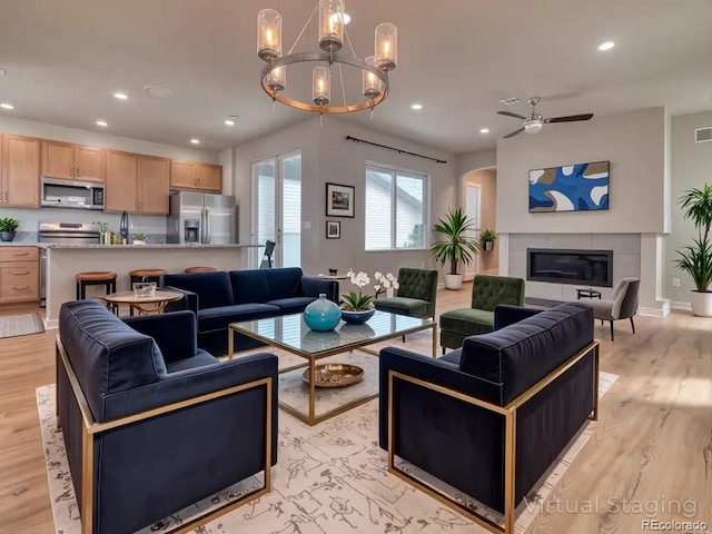 8018 Williams Fork Ave, Littleton, CO 80125 - living room with recessed lighting, light wood-style floors, ceiling fan, a chandelier, and a tiled fireplace