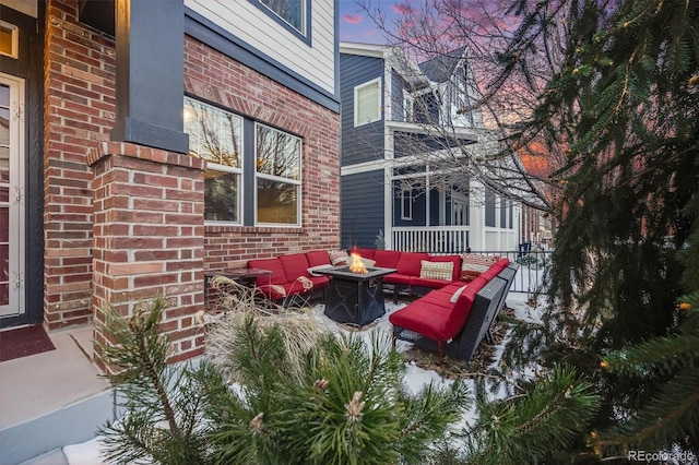 patio terrace at dusk featuring an outdoor living space with a fire pit