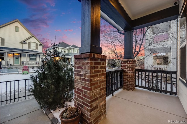 patio terrace at dusk featuring covered porch