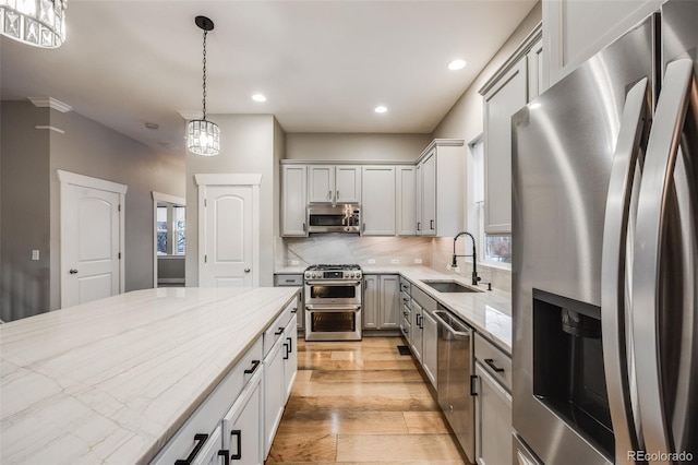 kitchen featuring sink, hanging light fixtures, plenty of natural light, stainless steel appliances, and backsplash