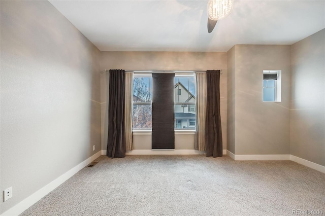 carpeted spare room featuring ceiling fan