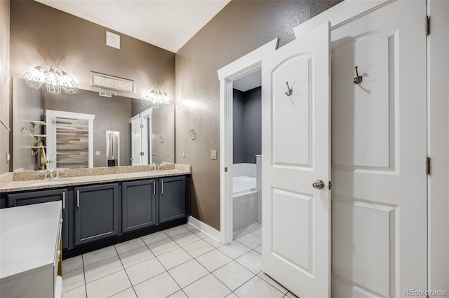 bathroom with vanity, tiled tub, and tile patterned floors